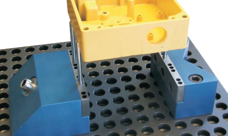 ALUMESS.maxx Niederzugspanner und Festblock mit 120° Prisma Anwendungsbeispiel zusammen mit Aufnahmestiften auf Basisplatte